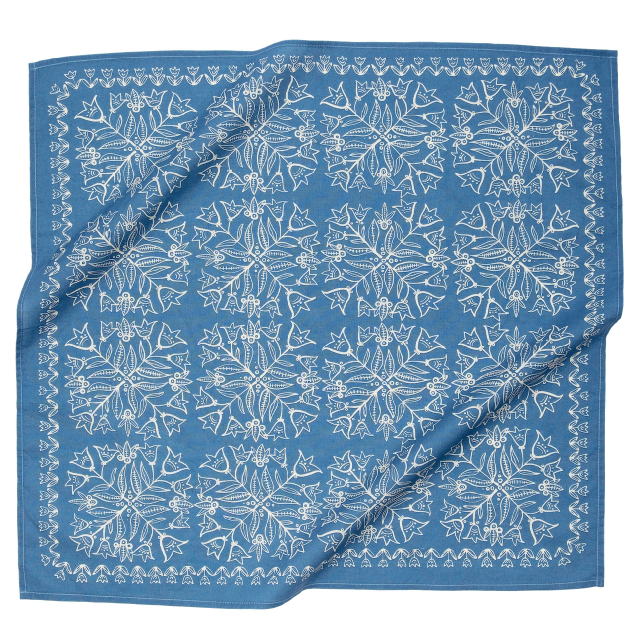 This image features a **square fabric bandana** with a **white symmetrical floral and botanical pattern** on a soft blue background. The intricate design consists of repeating motifs, including delicate leaves, flowers, and small decorative elements, creating a vintage or folk-art-inspired look. A decorative border frames the edges, enhancing its classic appeal. The fabric appears lightweight and breathable, making it a versatile accessory for wearing as a headband, neck scarf, or decorative accent.