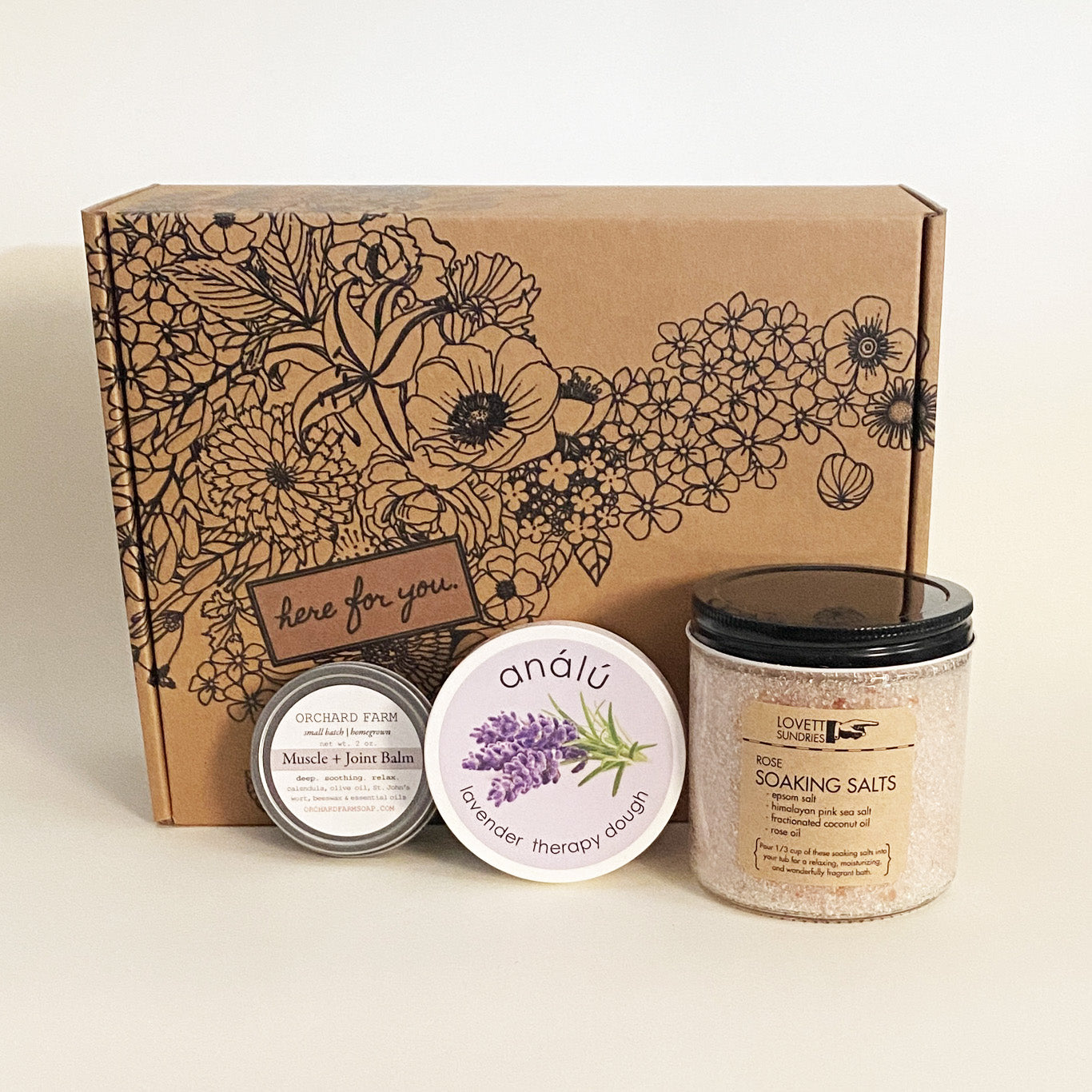 Chronic illness essentials care package with therapy dough, muscle balm, soaking salts, and a floral “Here For You” gift box