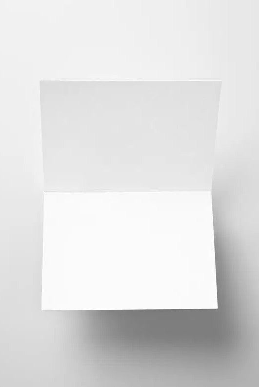 This image features a blank, open greeting card with a clean white interior, set against a neutral background. The card is positioned at an angle, showing both the left and right inner pages. It serves as a versatile canvas for handwritten messages, printed text, or creative designs, making it suitable for a variety of occasions.