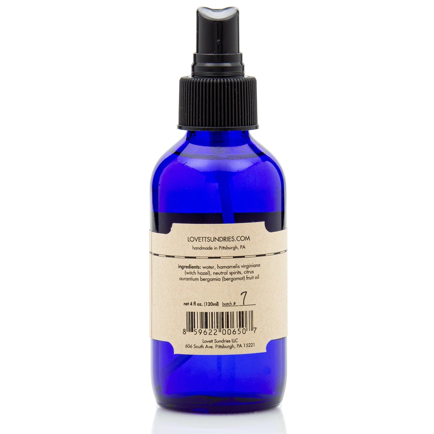 Cobalt blue glass spray bottle with a kraft paper label listing ingredients; bottle contains Lovett Sundries Cooling Mist.