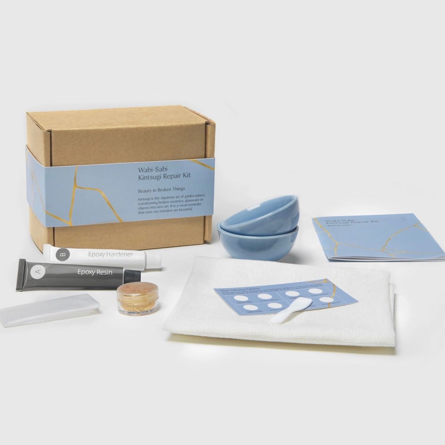 Kintsugi repair kit with materials and tools on a white background