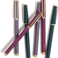 Six pens in rich jewel tones (purple, teal, and burgundy) with matte finishes and gold accents, arranged diagonally on a white surface.