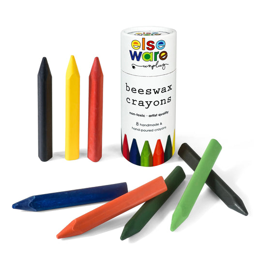 A set of eight colorful beeswax crayons, some standing and others lying flat, surrounds a cylindrical container labeled "Elseware unplug beeswax crayons." The crayons are hand-poured, non-toxic, and artist quality.